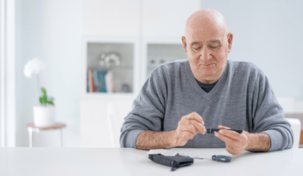 Older man testing his blood sugar with a diabetes  glucose test kit